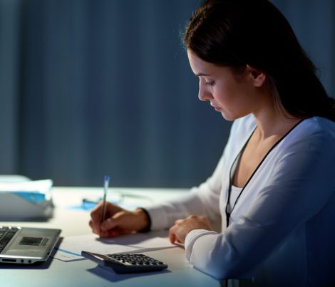 business, accounting, overwork, deadline and people concept - woman with tax form and calculator working at night office